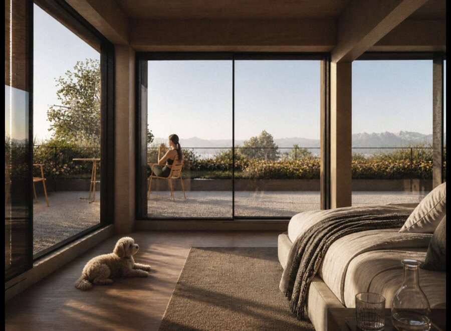 Experience serene living in this modern bedroom with expansive floor-to-ceiling windows offering breathtaking views of the landscape and water.