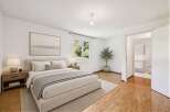 This stunning bedroom offers a serene retreat with its neutral color palette and ample natural light.