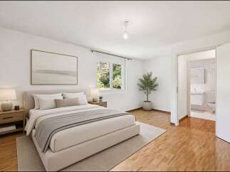 This stunning bedroom offers a serene retreat with its neutral color palette and ample natural light.