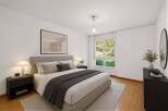 Step into this inviting bedroom, featuring a comfortable bed with a stylish gray throw and a neutral color palette.