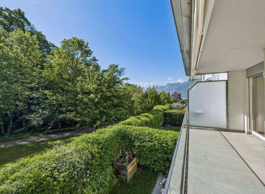 Enjoy breathtaking views from this stunning property! This home features a spacious balcony overlooking lush greenery and distant mountains.