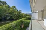 Enjoy breathtaking views from this stunning property! This home features a spacious balcony overlooking lush greenery and distant mountains.