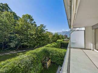 Enjoy breathtaking views from this stunning property! This home features a spacious balcony overlooking lush greenery and distant mountains.