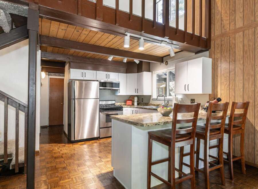 Step into this charming kitchen, featuring a stylish island with seating, perfect for casual dining and entertaining.