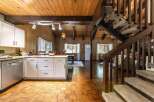 Step into this charming cabin-style home, featuring a warm and inviting interior with wood paneling and a cozy atmosphere.