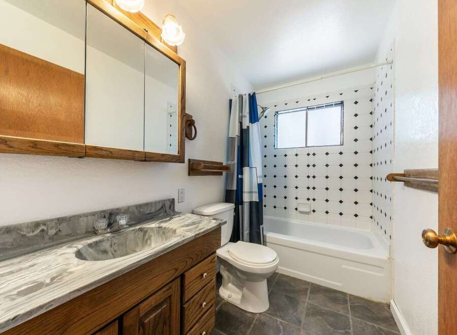This charming bathroom features a classic design with a wooden vanity and a stylish countertop.