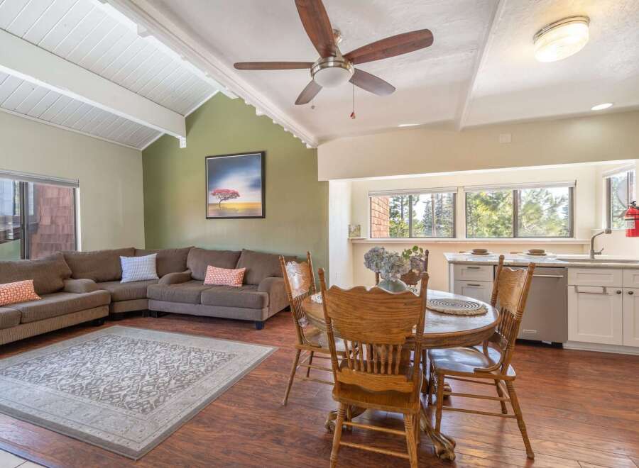 This stunning property boasts a spacious living area with a cozy sectional sofa and a beautiful rug, perfect for relaxing or entertaining.