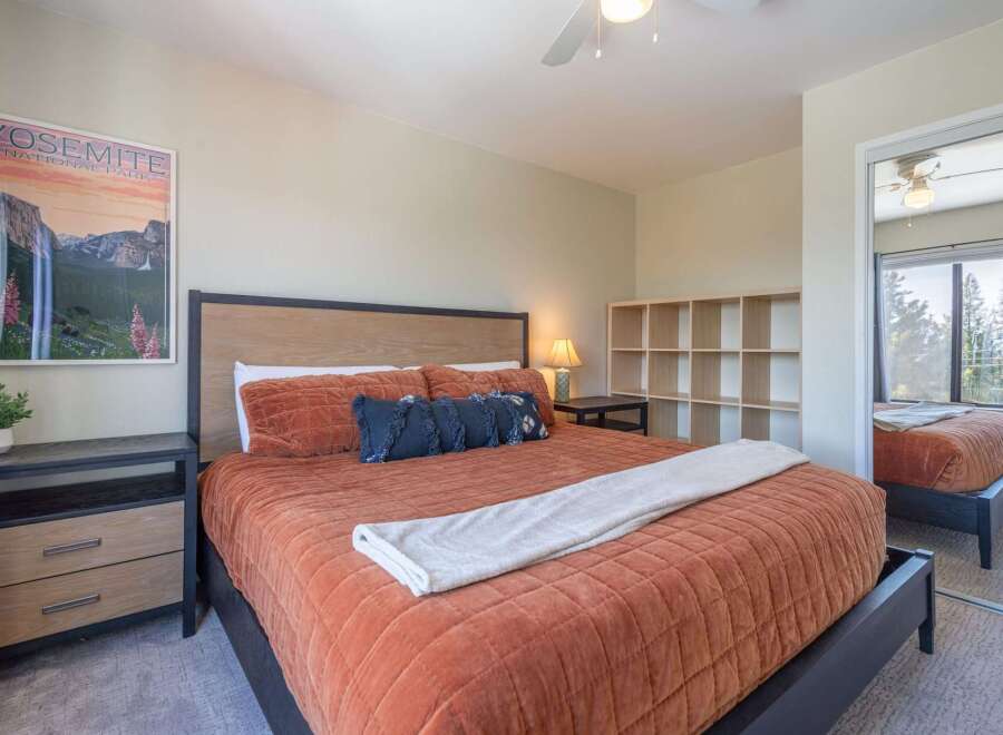 This inviting bedroom features a cozy bed with a warm-toned comforter, perfect for relaxing after a long day.