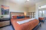 This inviting bedroom features a cozy bed with a warm-toned comforter, perfect for relaxing after a long day.
