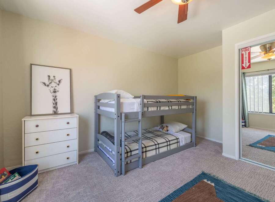 This charming bedroom features a cozy bunk bed, perfect for kids or guests.