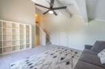 Step into this inviting living space featuring a modern ceiling fan and a stylish rug.