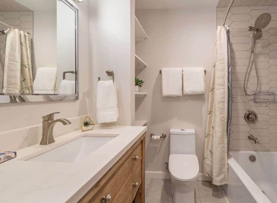 This modern bathroom features a sleek vanity with a marble countertop and a stylish faucet.