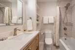 This modern bathroom features a sleek vanity with a marble countertop and a stylish faucet.