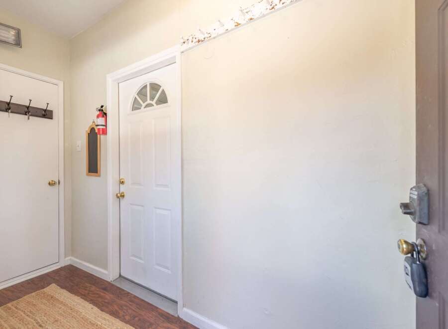 Step into this inviting entryway, featuring a bright white door with a stylish arched window.
