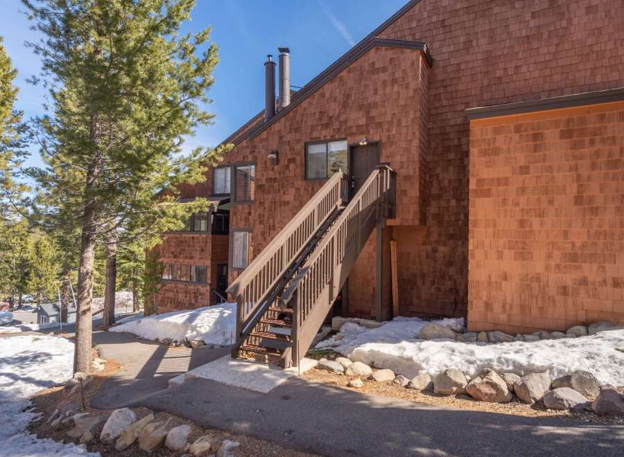 This charming property features a beautiful exterior with wooden shingles and a welcoming staircase.
