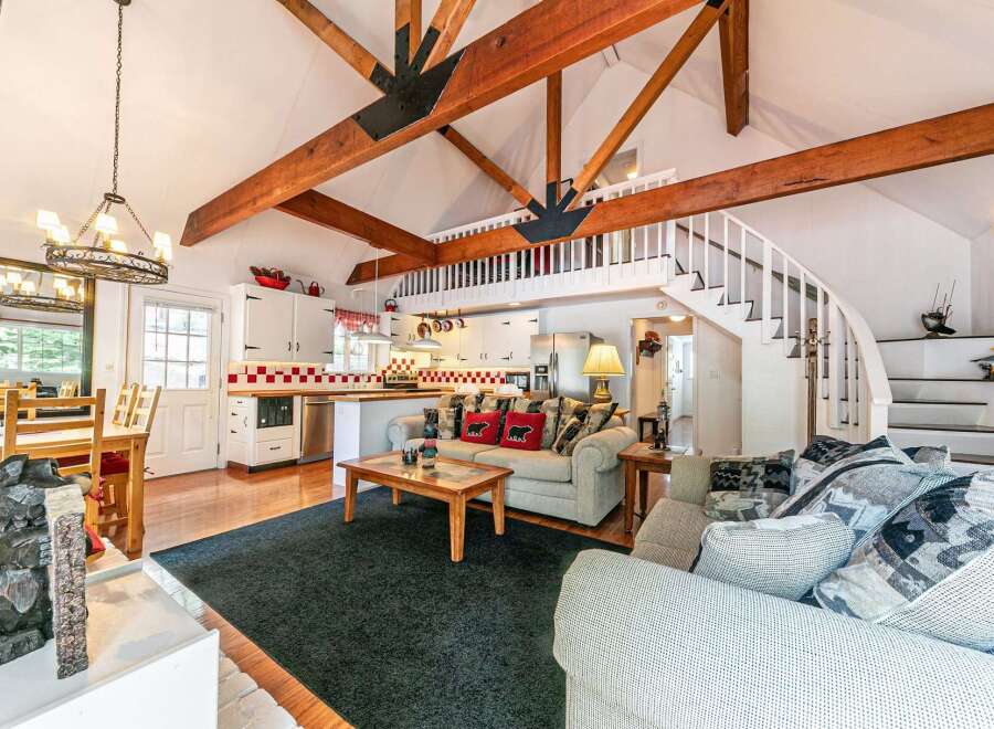 This charming property boasts a unique architectural design with exposed wooden beams and a loft area, creating a spacious and inviting atmosphere.