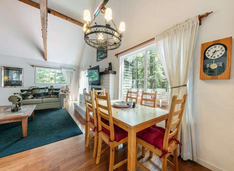 Step into this charming home featuring a cozy living room with a fireplace and a dining area with a large window.