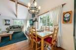 Step into this charming home featuring a cozy living room with a fireplace and a dining area with a large window.
