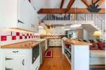 Step into this charming kitchen, featuring a unique red and white checkered backsplash and warm wooden countertops.