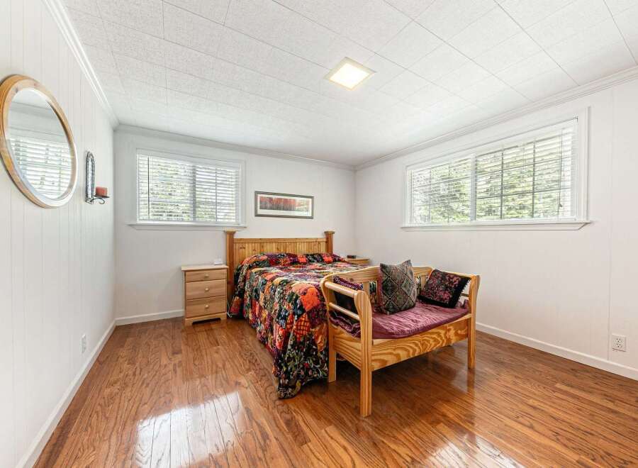 This inviting bedroom features a cozy bed with a vibrant quilt, creating a warm and welcoming atmosphere.