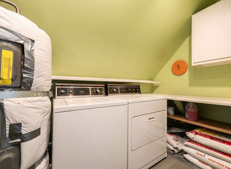 This laundry room offers a practical and functional space for your daily chores.