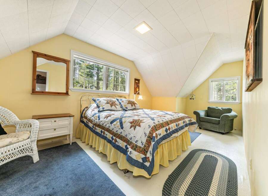 This charming bedroom features a cozy bed adorned with a colorful quilt, creating a warm and inviting atmosphere.