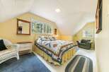 This charming bedroom features a cozy bed adorned with a colorful quilt, creating a warm and inviting atmosphere.