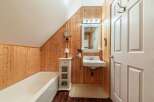 Step into a charming bathroom with rustic wood paneling that exudes warmth and character.