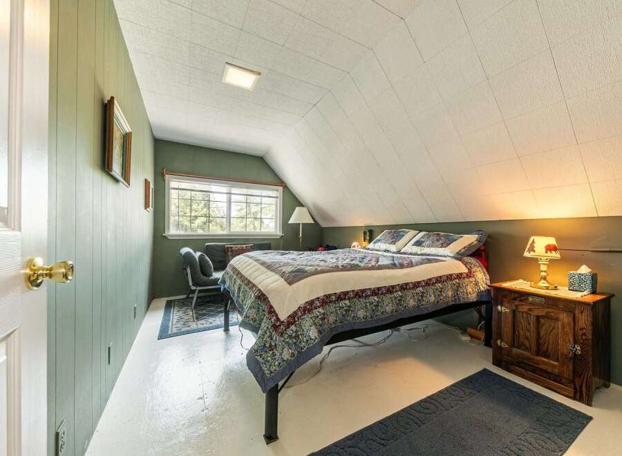 Step into this charming bedroom, featuring a cozy bed adorned with a beautiful quilt.