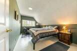 Step into this charming bedroom, featuring a cozy bed adorned with a beautiful quilt.