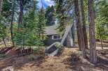 Nestled amidst towering trees, this charming A-frame cabin offers a serene escape.
