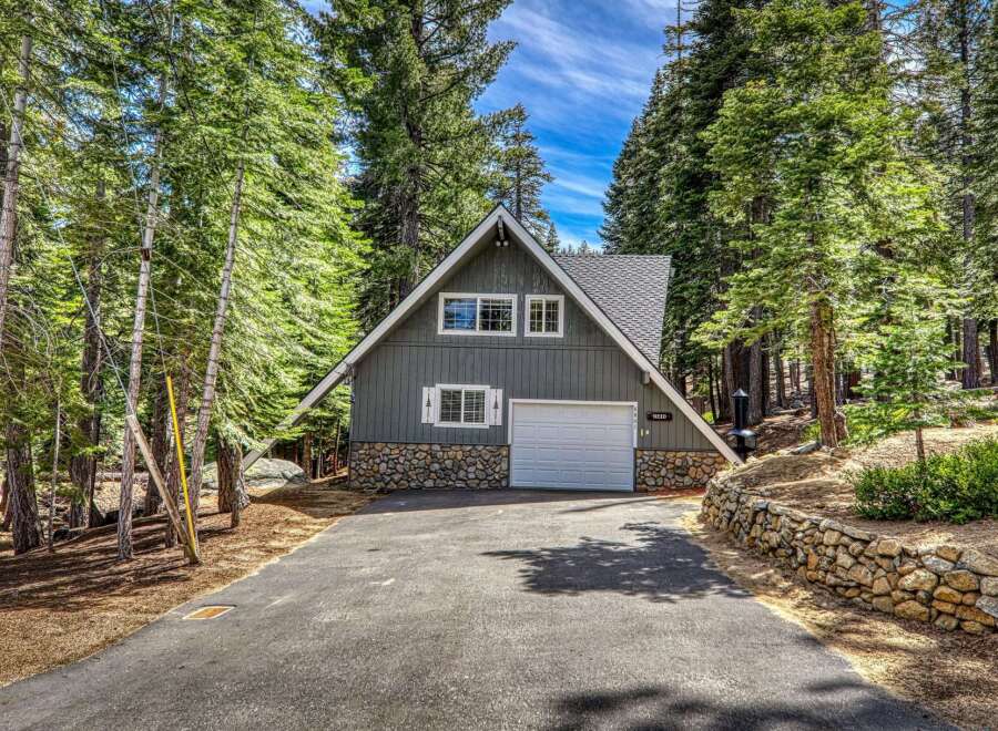 Nestled amidst towering trees, this charming A-frame home offers a serene escape.