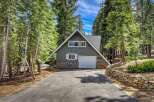 Nestled amidst towering trees, this charming A-frame home offers a serene escape.