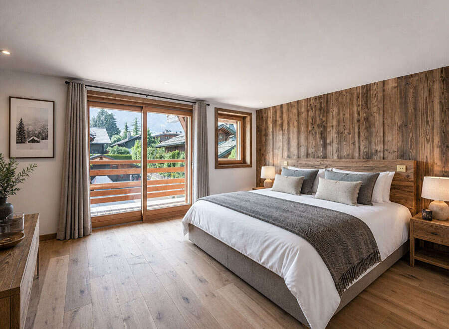 Experience luxury living in this stunning bedroom featuring a rustic wooden accent wall and elegant hardwood floors.
