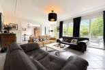 Experience luxurious living in this spacious living room, featuring comfortable seating arrangements and elegant decor.