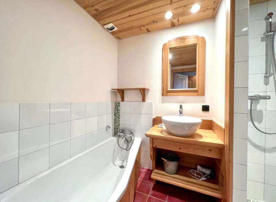This charming bathroom features a unique wooden ceiling and accents, creating a warm and inviting atmosphere.