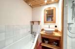 This charming bathroom features a unique wooden ceiling and accents, creating a warm and inviting atmosphere.