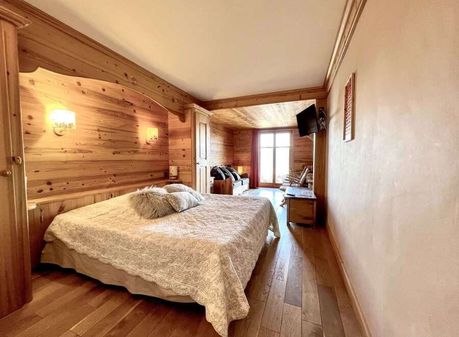 Experience rustic charm in this cozy bedroom! Featuring beautiful wood paneling, a comfortable bed, and a warm ambiance, this space is perfect for relaxation.