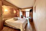 Experience rustic charm in this cozy bedroom! Featuring beautiful wood paneling, a comfortable bed, and a warm ambiance, this space is perfect for relaxation.