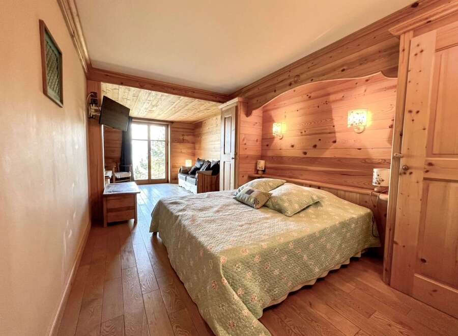 This cozy bedroom features a warm wooden interior, creating a rustic and inviting atmosphere.