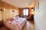 This charming bedroom features warm wooden paneling and a cozy atmosphere, perfect for a relaxing retreat.