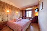 Cozy bedroom with wooden paneling and a comfortable bed.