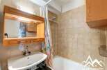 Discover this charming bathroom featuring a well-maintained vanity with a mirror and storage.
