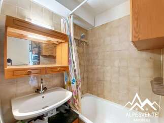 Discover this charming bathroom featuring a well-maintained vanity with a mirror and storage.