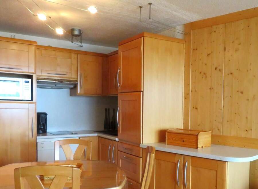 This charming kitchen features warm wooden cabinetry and a functional layout, perfect for preparing meals.