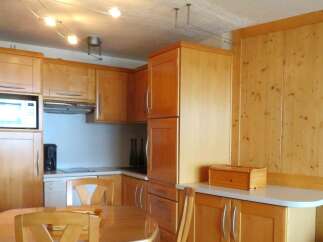 This charming kitchen features warm wooden cabinetry and a functional layout, perfect for preparing meals.