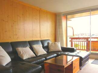 This stunning property boasts a modern living space with a comfortable black leather sectional sofa, perfect for relaxation.