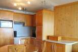 This charming kitchen features warm wooden cabinetry and a functional layout, perfect for preparing meals.