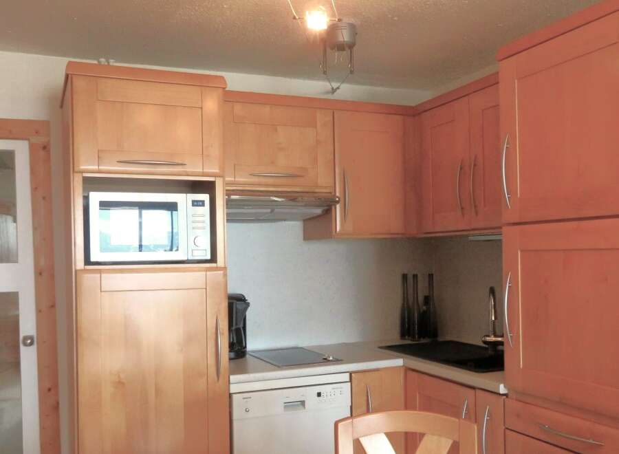 This charming kitchen features warm wooden cabinetry, creating a cozy and inviting atmosphere.