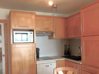 This charming kitchen features warm wooden cabinetry, creating a cozy and inviting atmosphere.